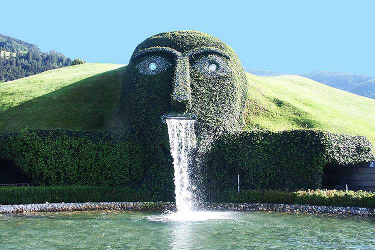 Il celebre Gigante dello Swarovski Crystal Worlds accoglie i visitatori con i suoi occhi di cristallo e la cascata che sgorga dalla bocca.