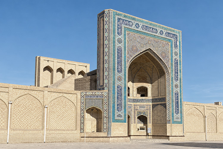 Uno dei grandi portali monumentali di Bukhara, decorato con mosaici geometrici e calligrafie nei toni del blu e del turchese.