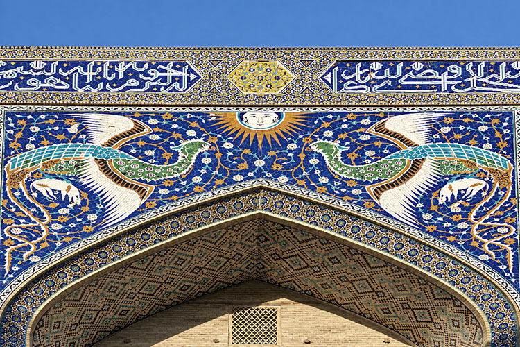 Il monumentale portale della Madrasa Nadir Divan-Begi, decorato con mosaici blu, turchesi e figure animali stilizzate.